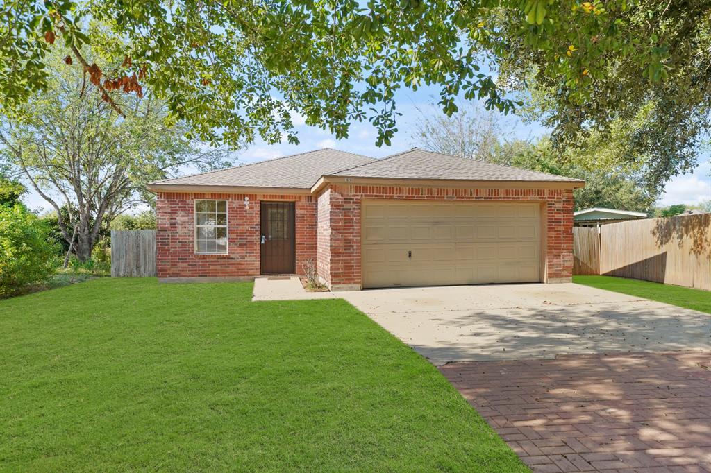 a front view of a house with a garden and yard