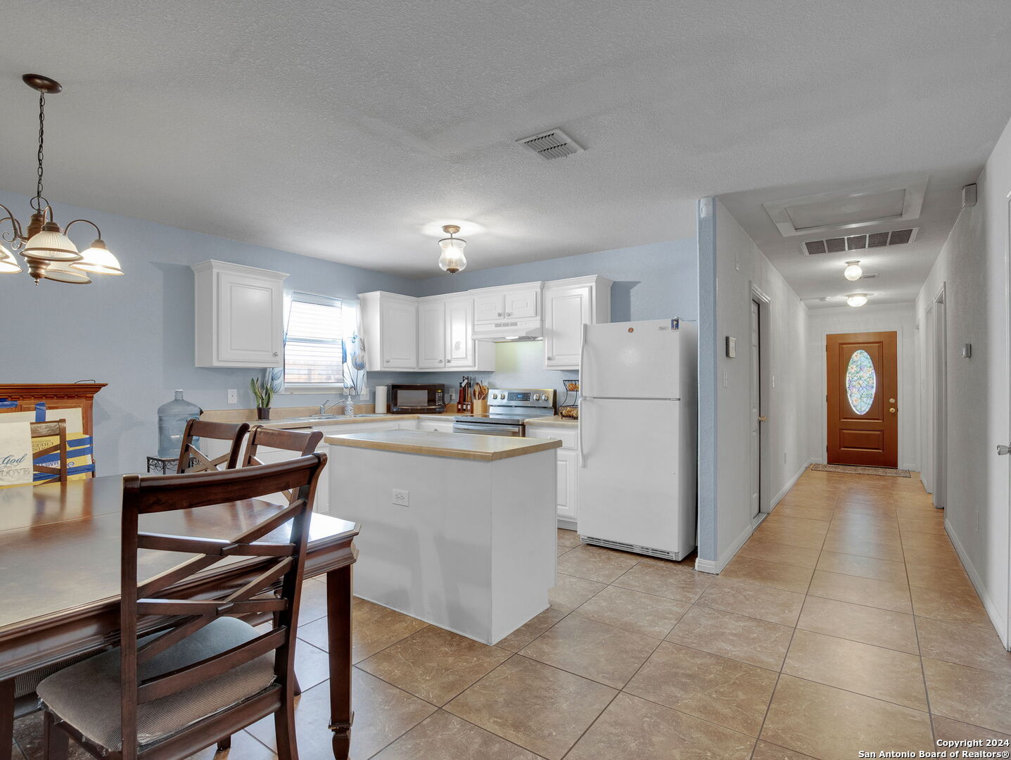 a kitchen with a refrigerator and a wooden cabinets