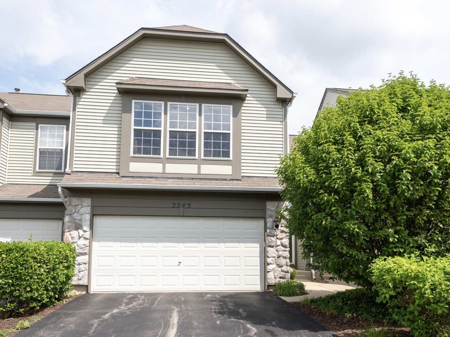 a front view of a house with a yard and garage