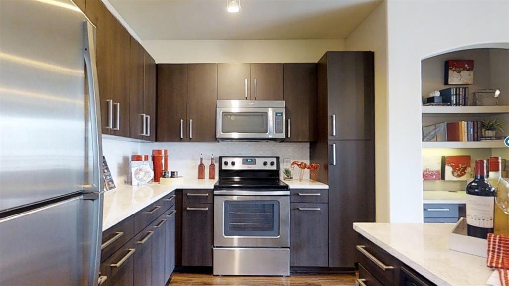 a kitchen with stainless steel appliances a stove microwave and refrigerator