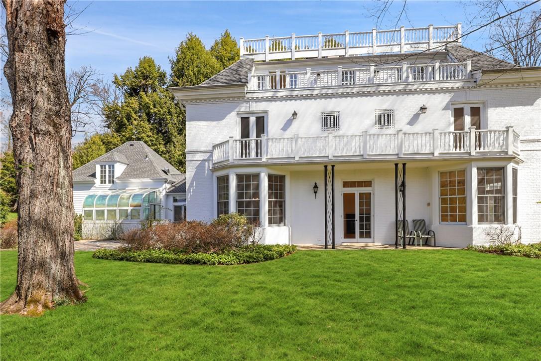 Rear view of house featuring a lawn and a balcony