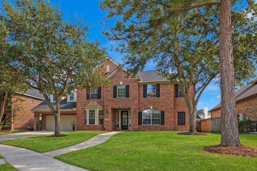 front view of a brick house with a yard