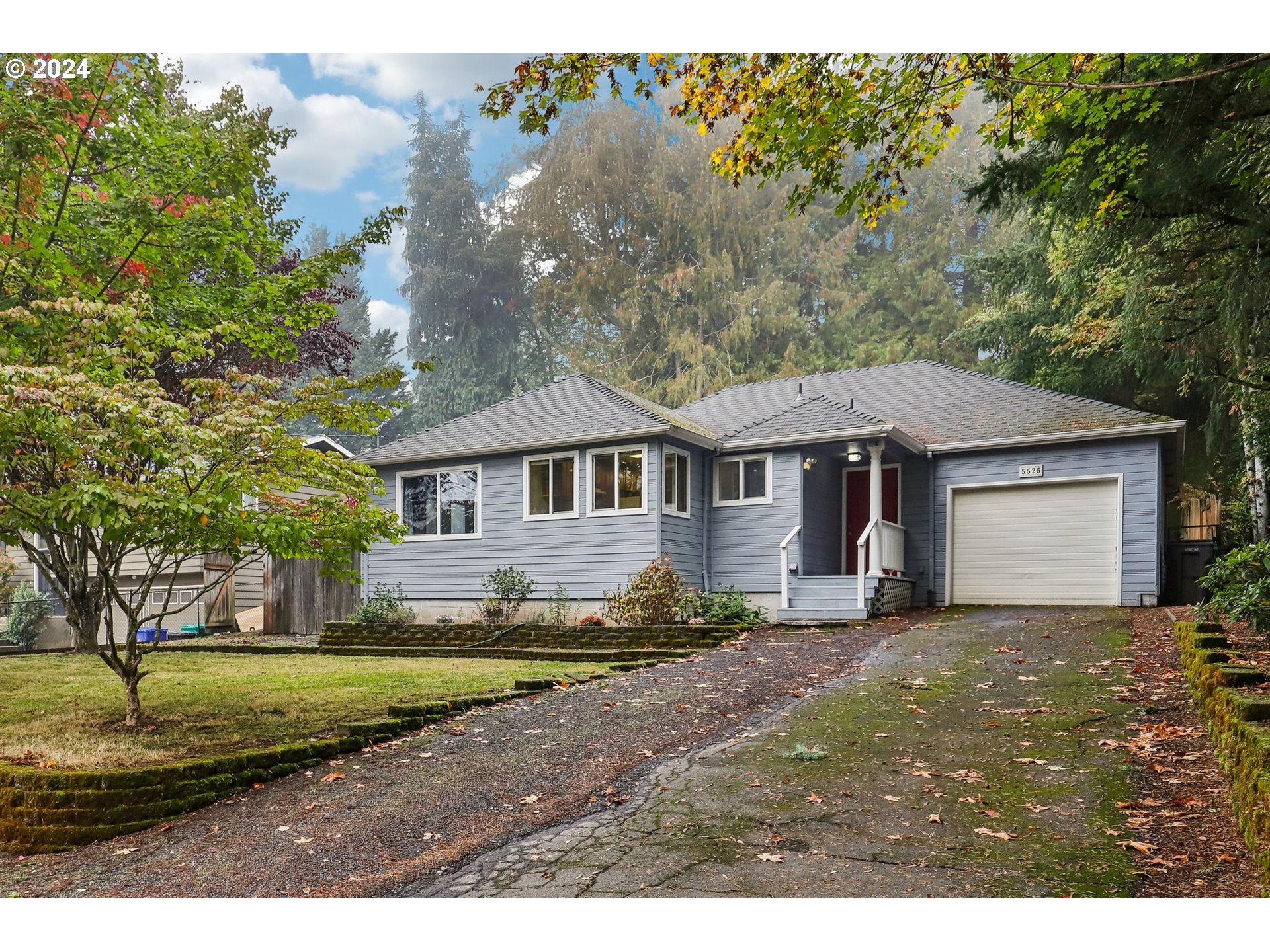 a view of a yard in front of a house with large trees