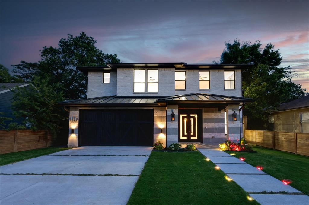 View of front facade featuring a garage, french doors, and a lawn