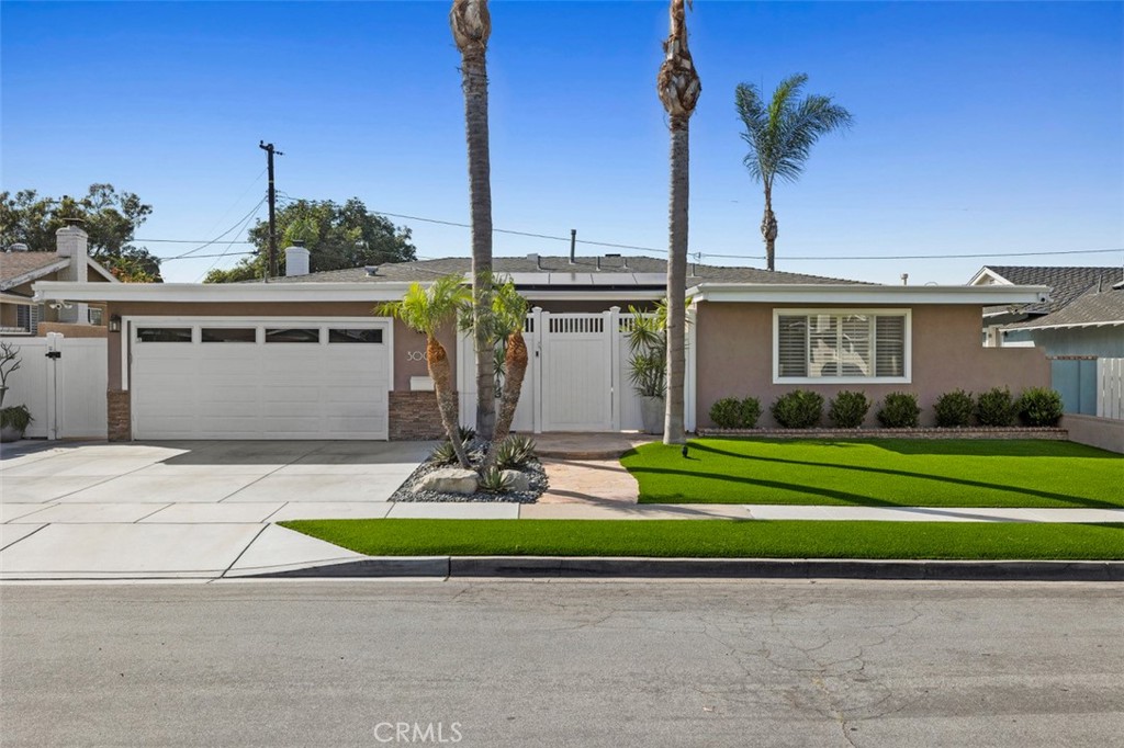 a front view of a house with garden and trees