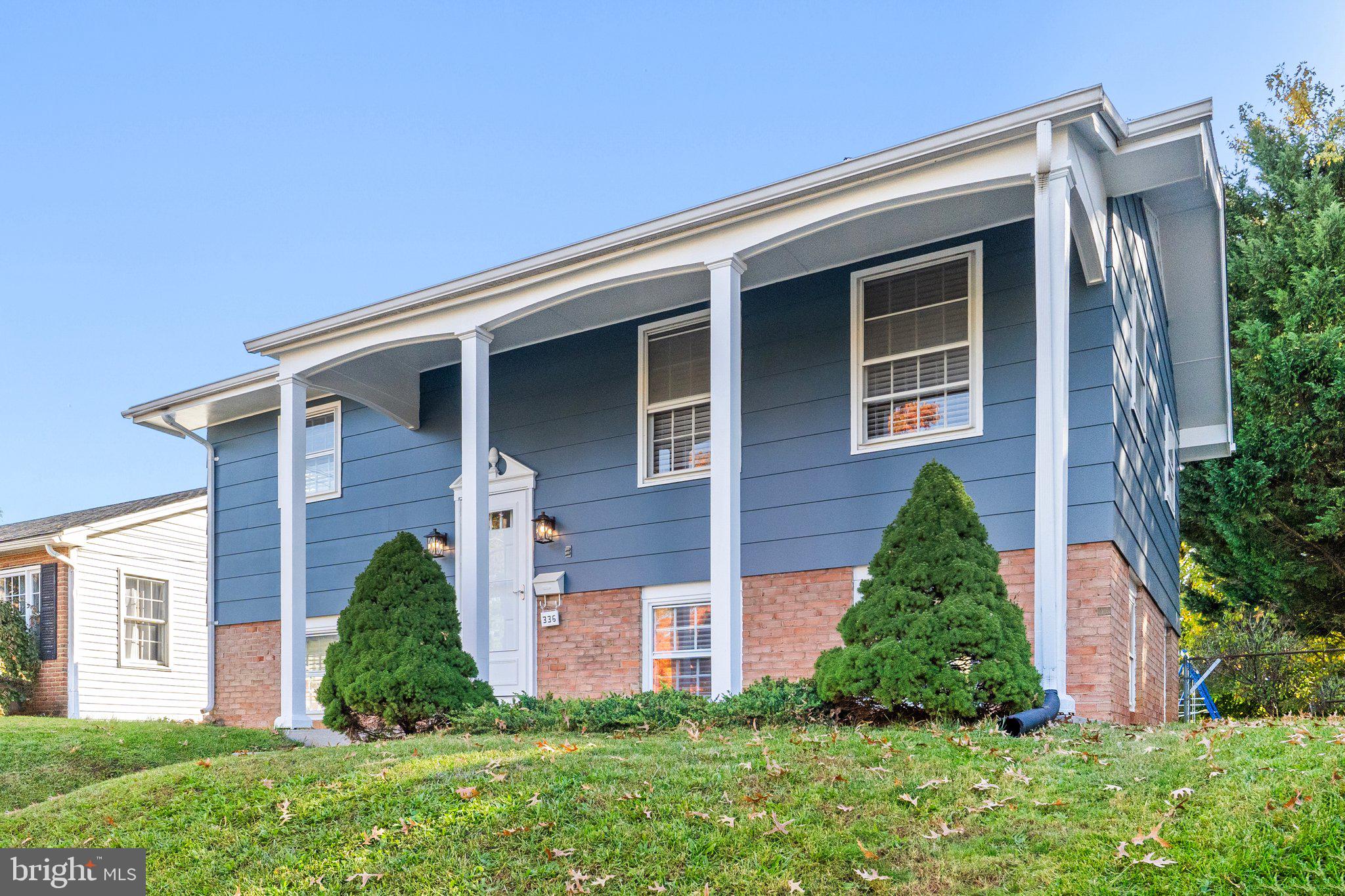 a front view of a house with a yard and trees