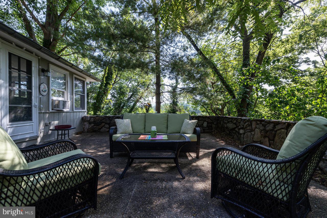 a view of a chair and tables in the back yard of the house