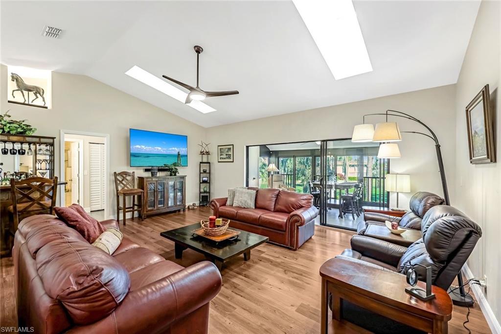 a living room with furniture a ceiling fan a fireplace and a chandelier