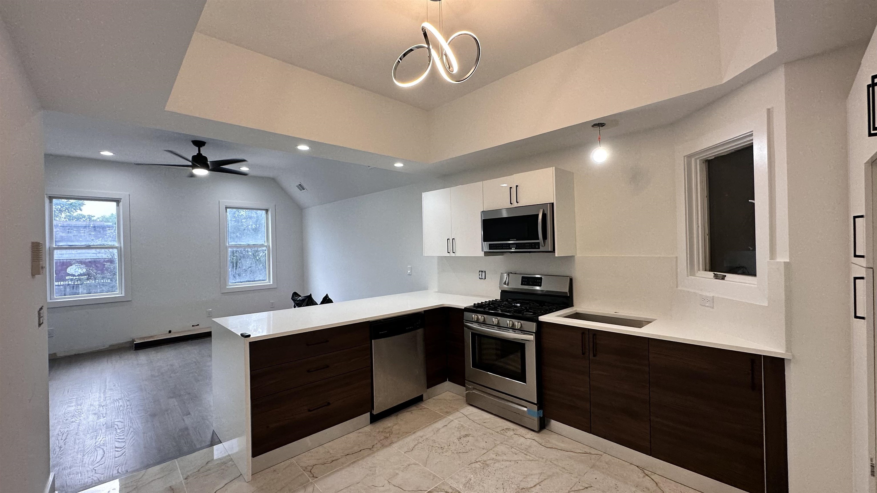 a kitchen with a sink stainless steel appliances and chandelier