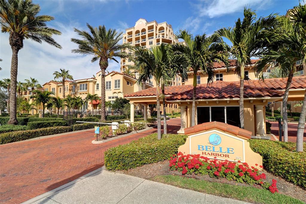 a front view of multi story residential apartment building with yard and sign board