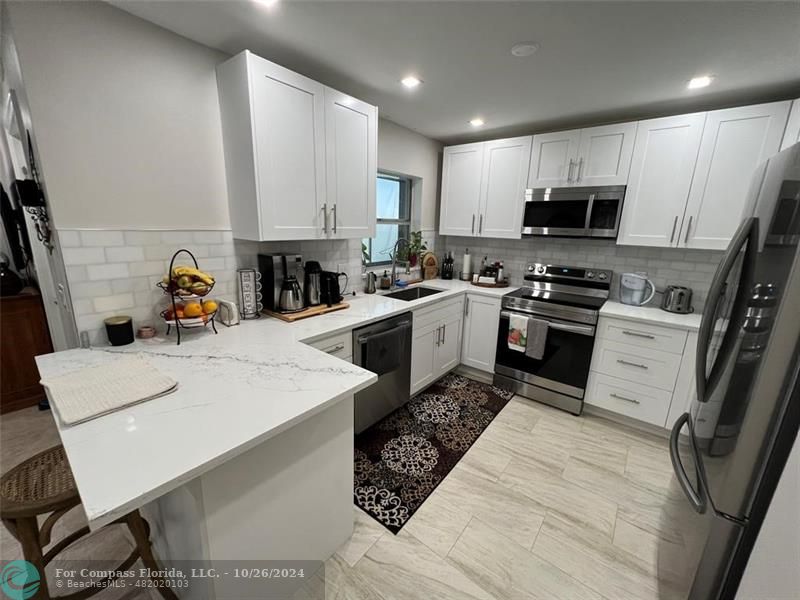 a kitchen with a sink a stove and chairs