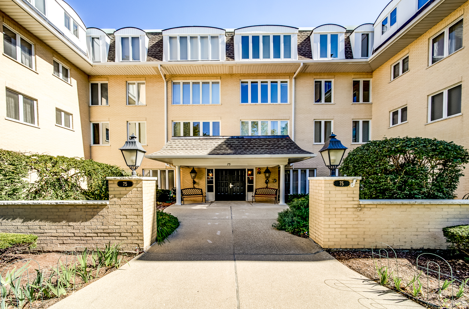 a front view of a residential apartment building with a yard