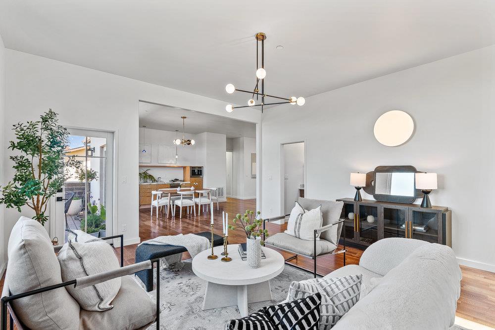 a living room with furniture a dining table and a potted plant