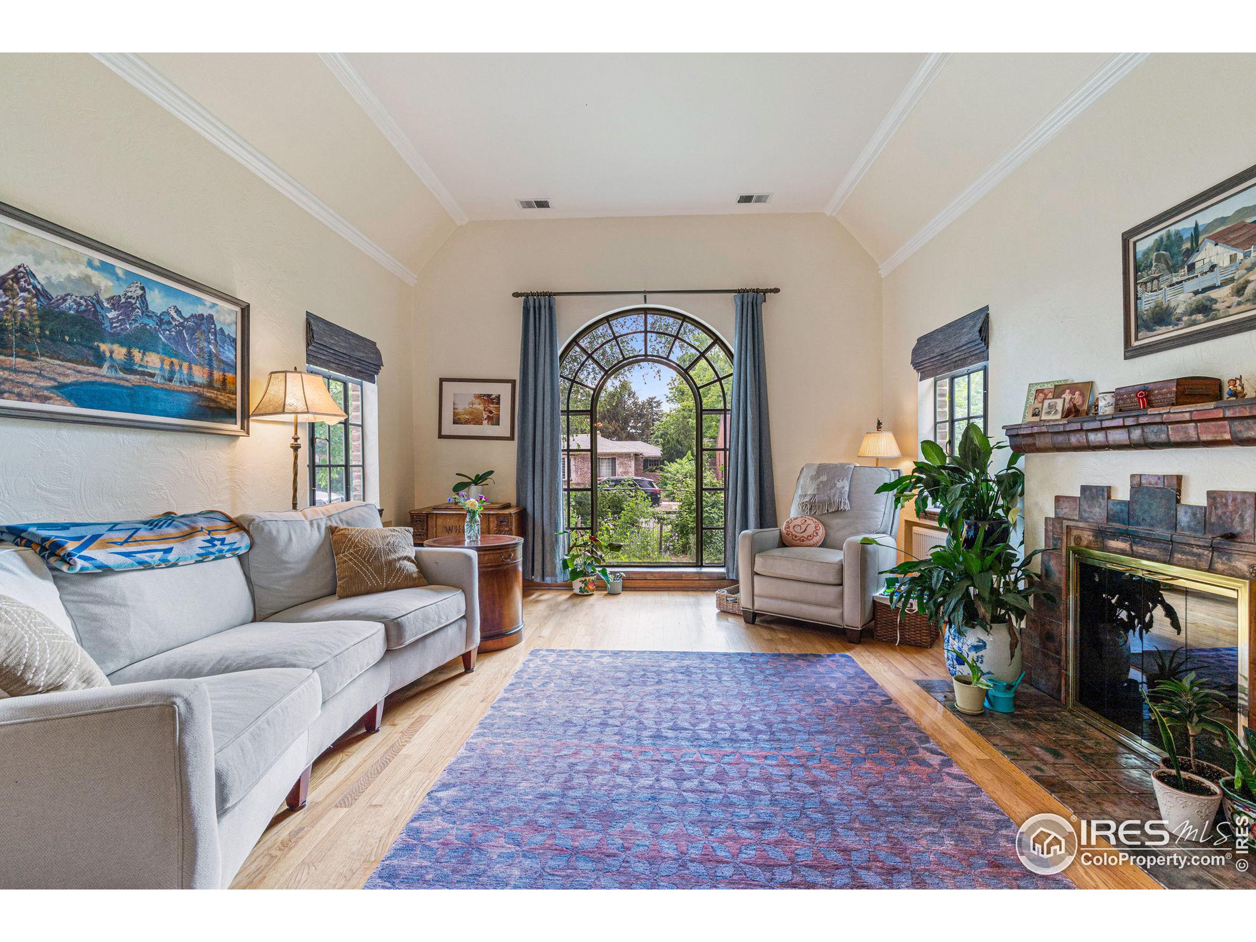 a living room with furniture large window and a fireplace