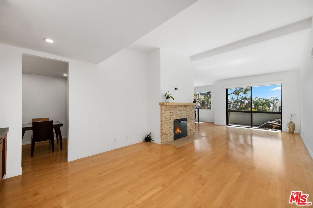 a view of empty room with wooden floor and fireplace