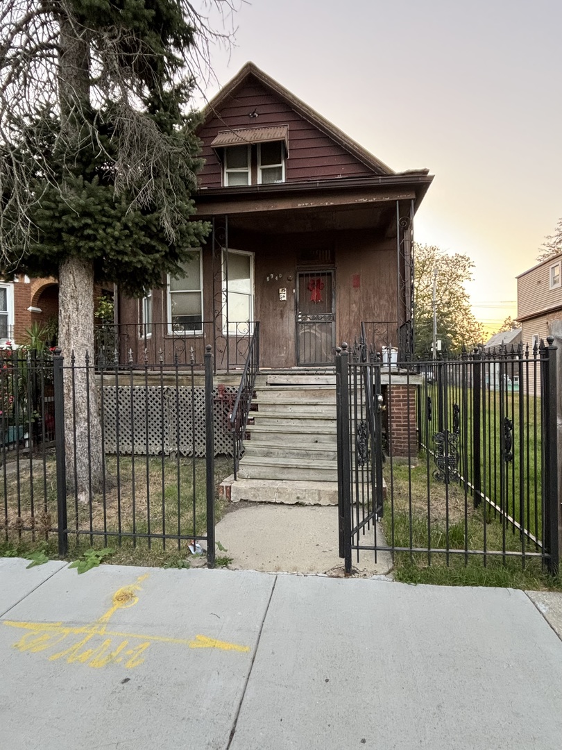 a view of a house with a small yard and wooden fence