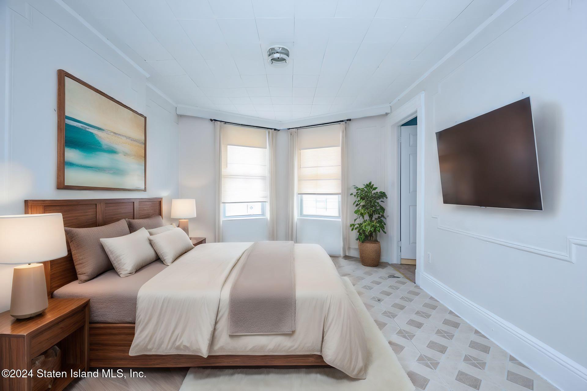 a bedroom with a bed and a flat screen tv