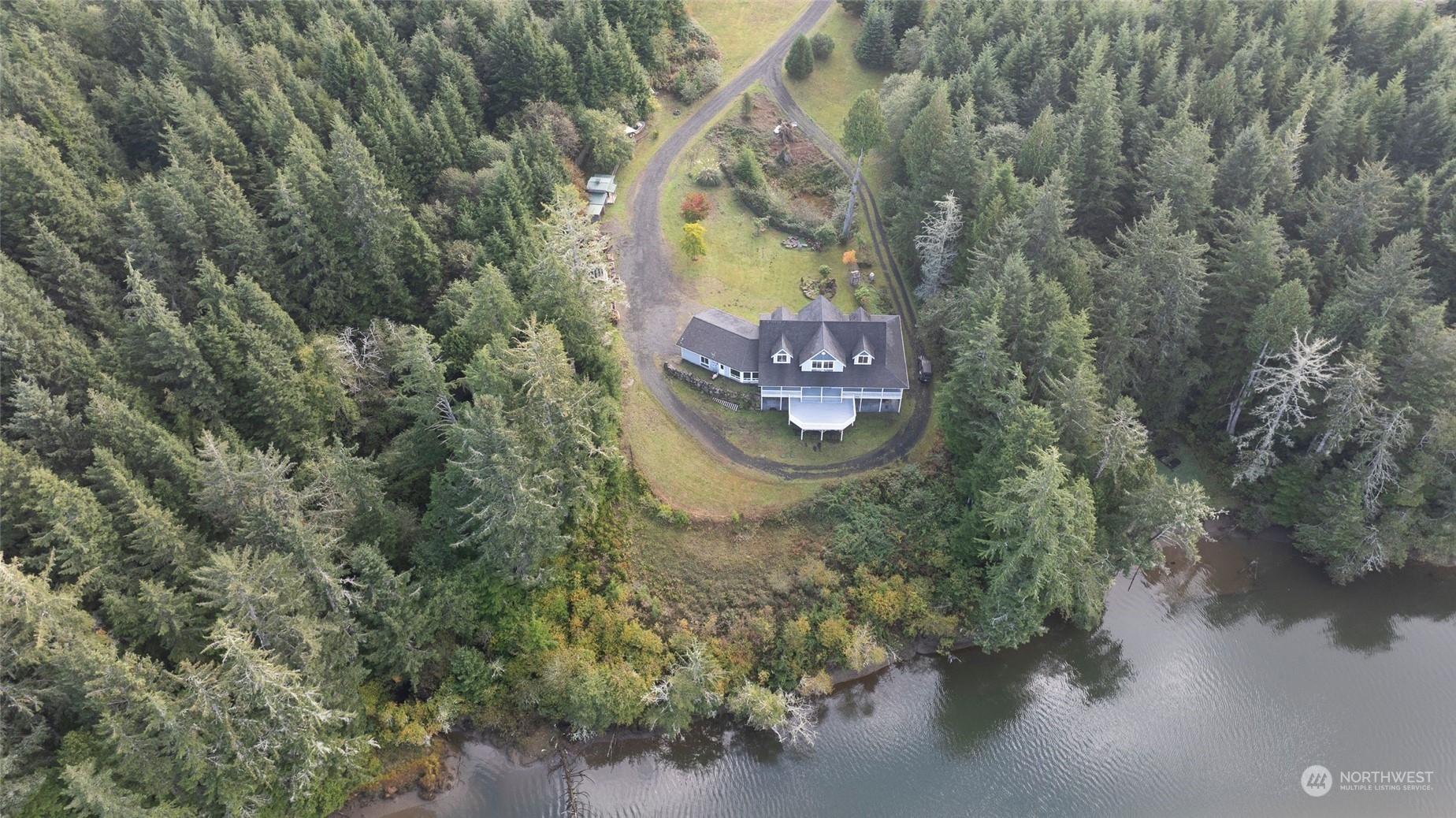 a aerial view of a house with a yard and large trees