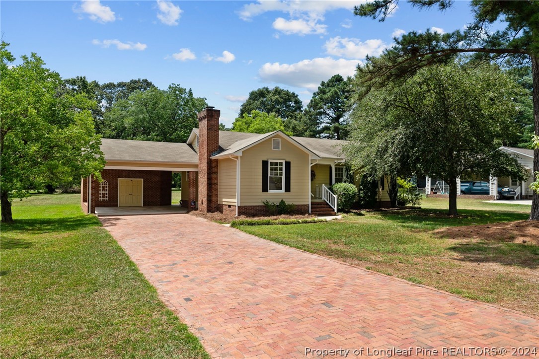 a front view of a house with a yard and trees