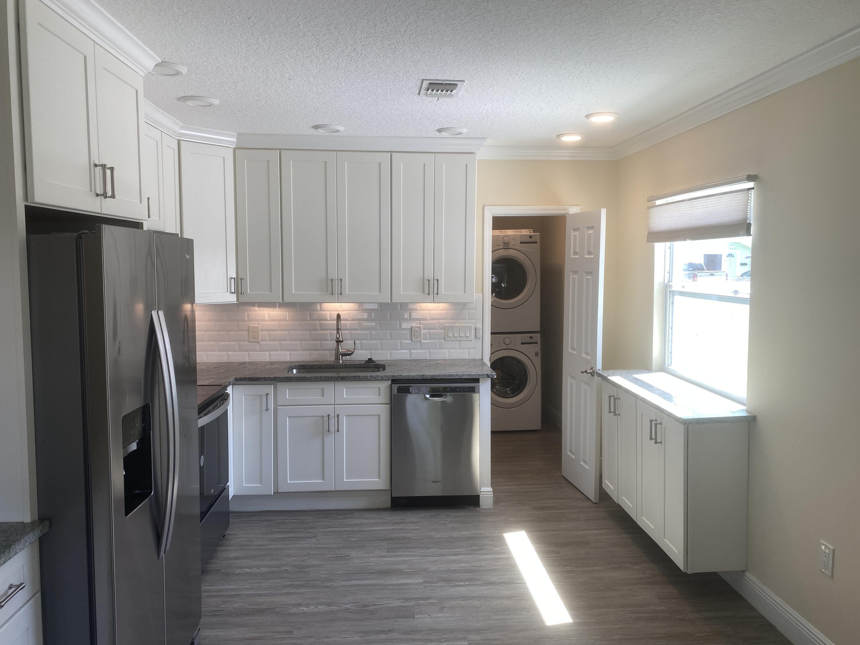 a kitchen with stainless steel appliances granite countertop a refrigerator and a stove top oven