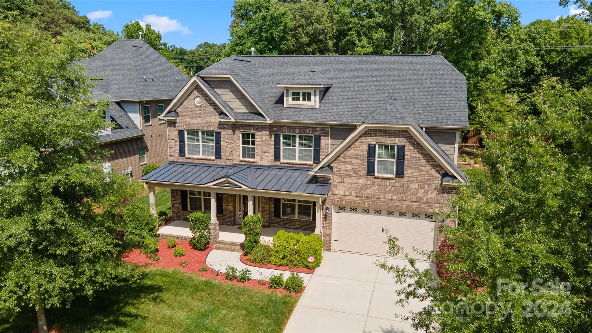 a aerial view of a house with a yard plants and large tree