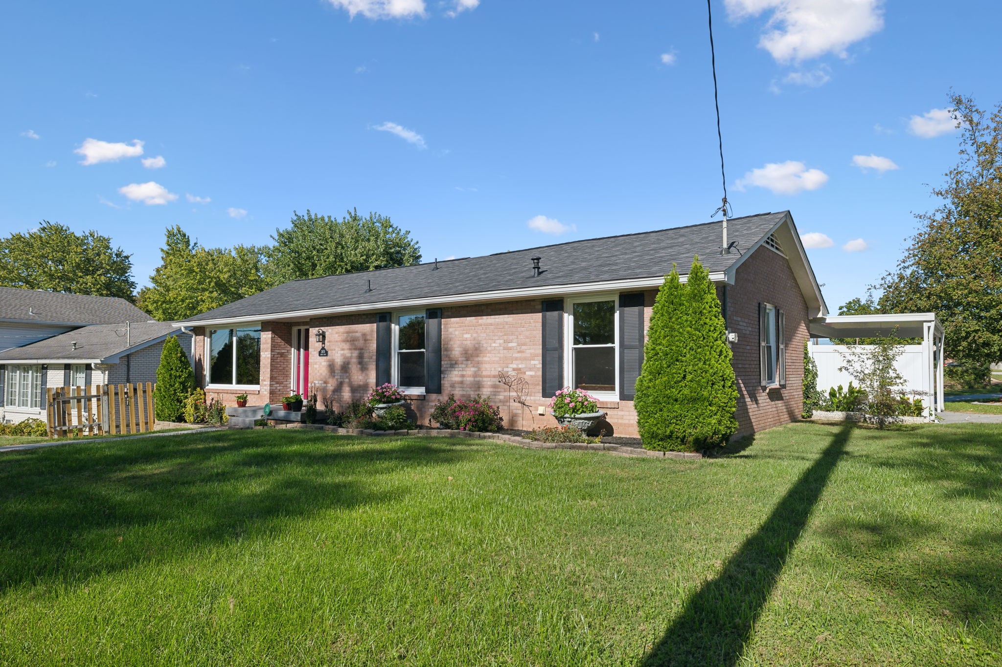 a view of a house with a big yard and potted plants