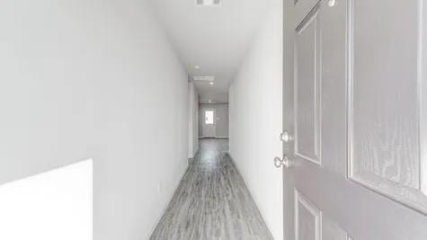 a view of a hallway with wooden floor