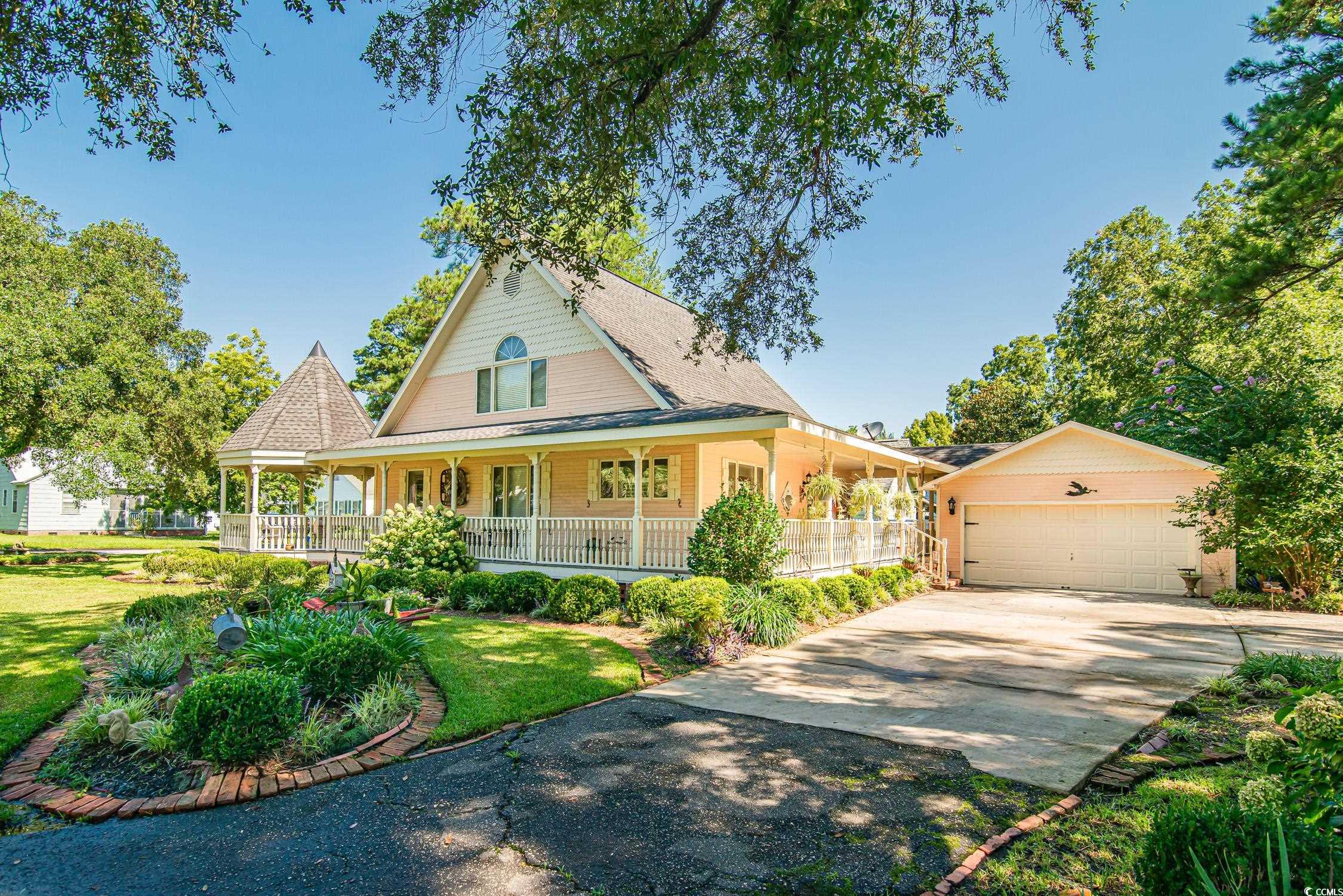 Country-style home featuring a front lawn, covered