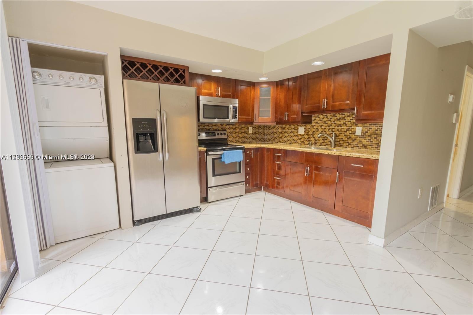 a kitchen with stainless steel appliances granite countertop a refrigerator and a sink