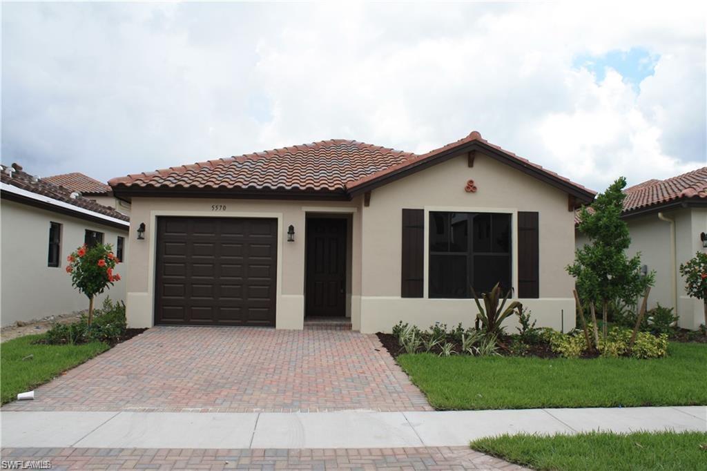 a front view of a house with a garden and yard