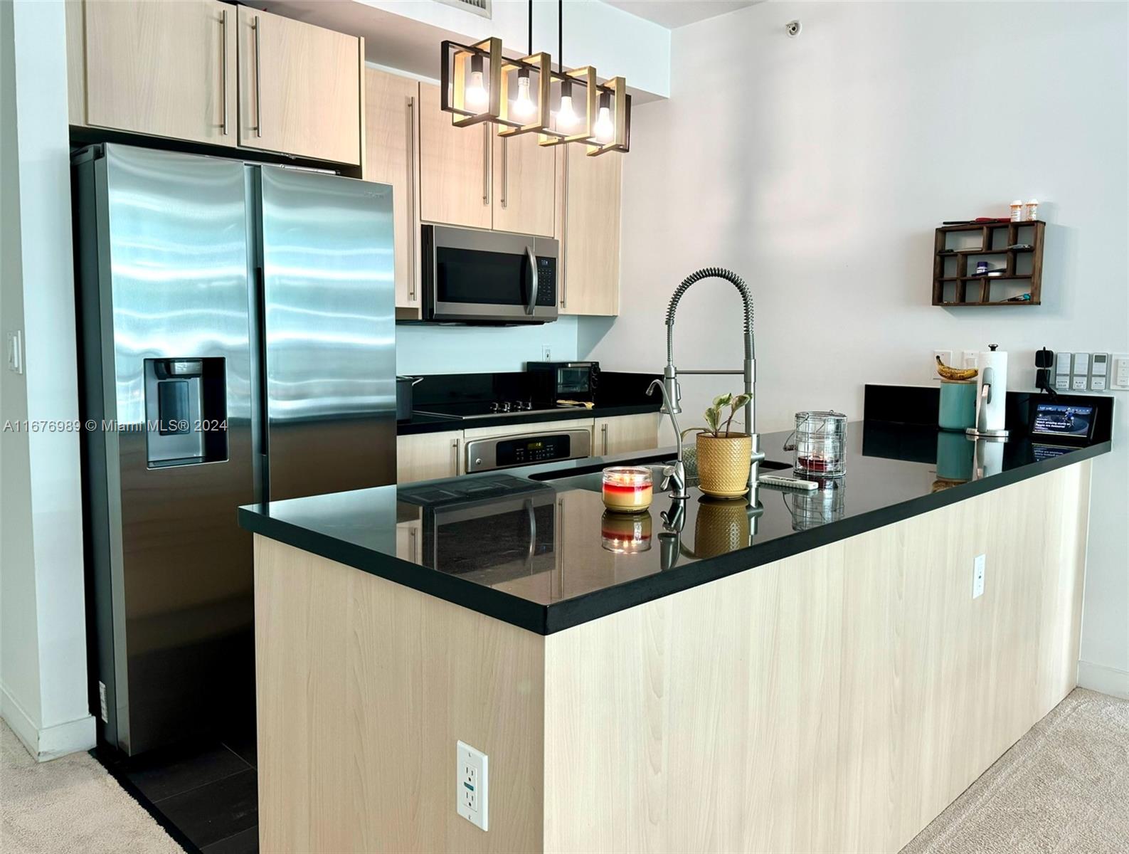 a kitchen with stainless steel appliances granite countertop a sink and a refrigerator