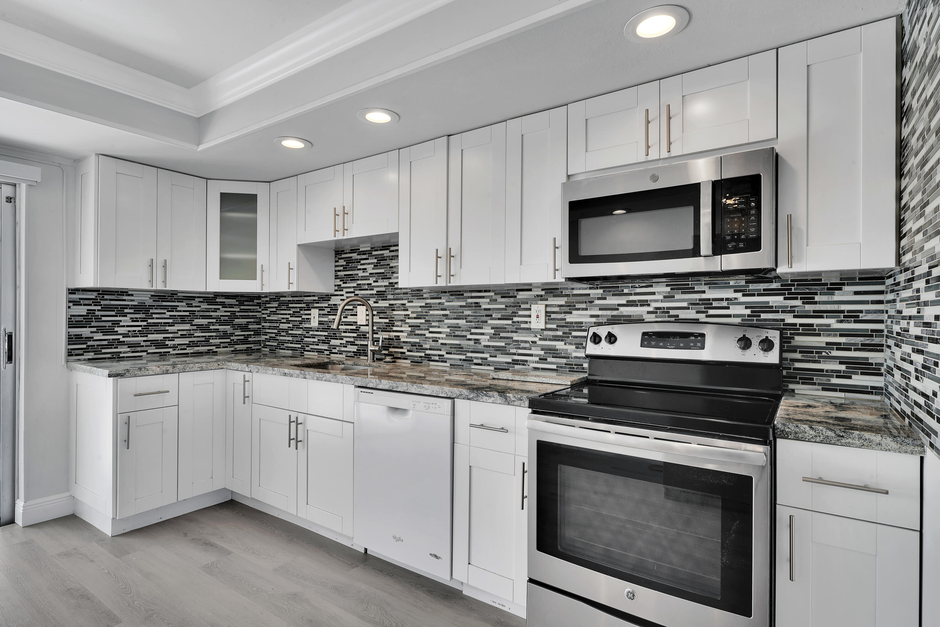 a kitchen with cabinets stainless steel appliances a sink and dishwasher