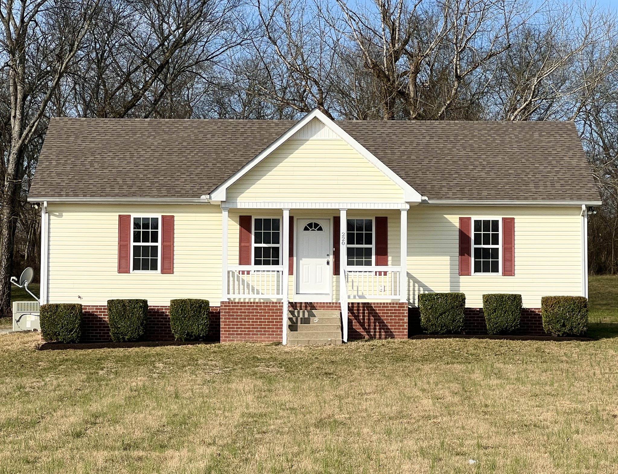 a front view of a house with a yard and seating space