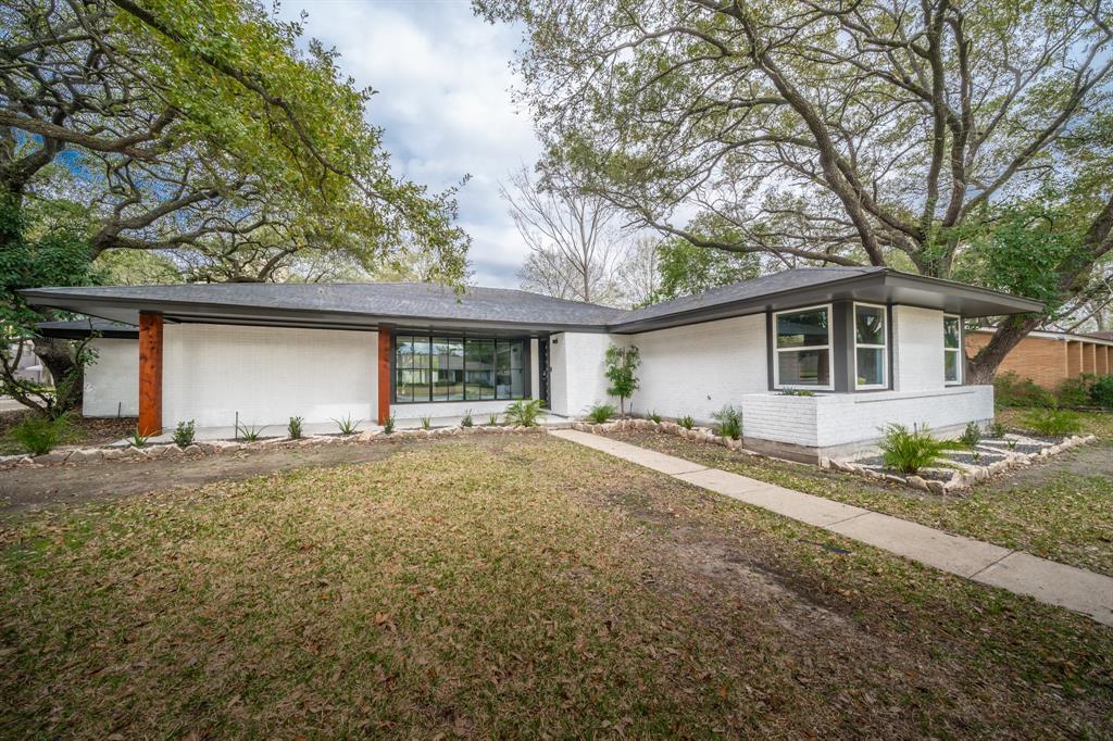 a view of a house with a yard and large tree