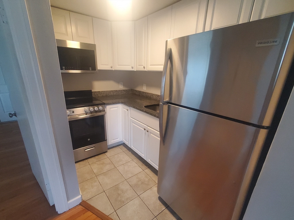 a kitchen with a refrigerator sink and cabinets