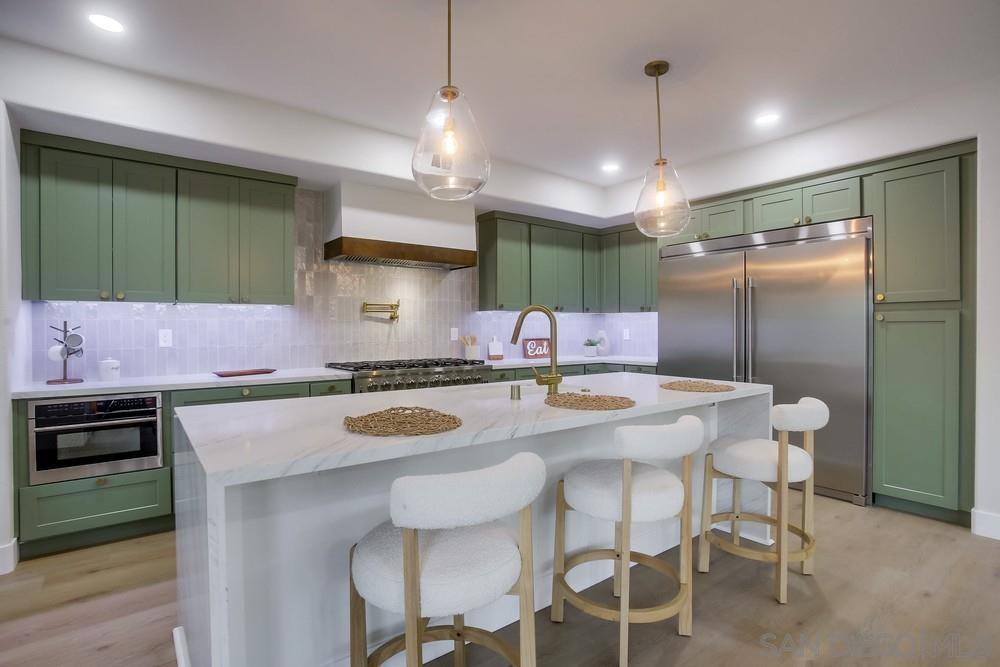 a kitchen with a table chairs refrigerator and cabinets