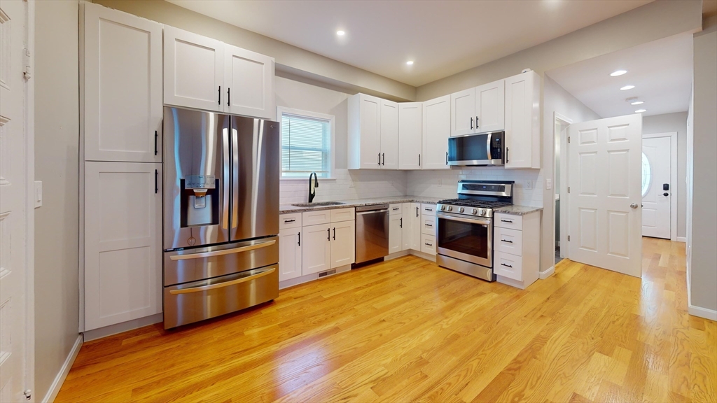 a kitchen with stainless steel appliances a refrigerator and a stove top oven