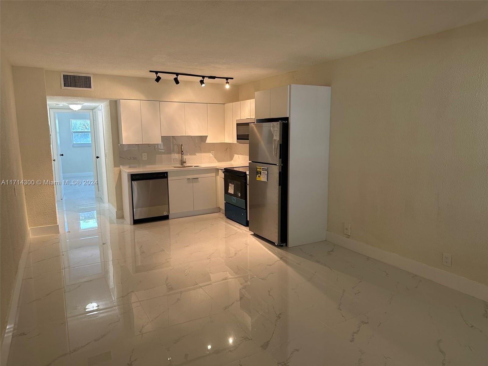 a large kitchen with cabinets and stainless steel appliances