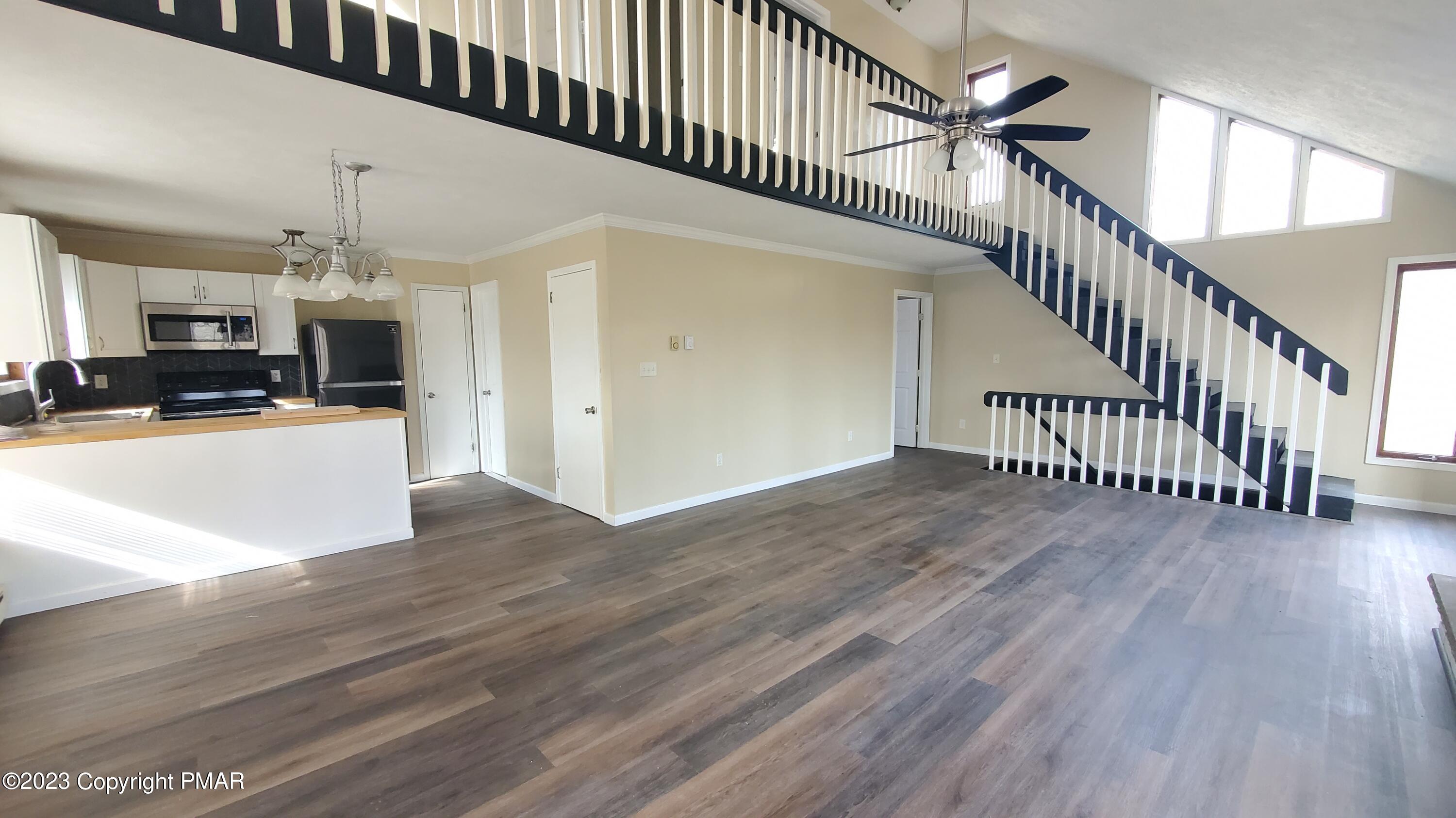 a view of a livingroom with wooden floor and staircase