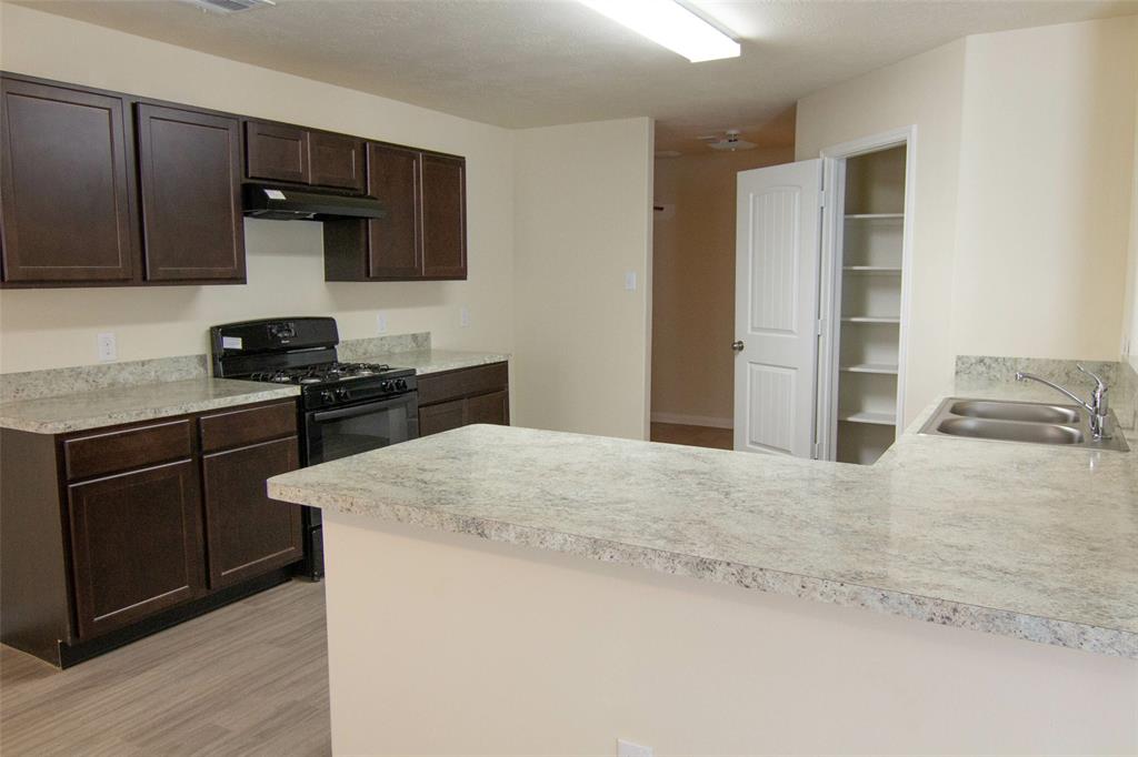 a kitchen with granite countertop cabinets stainless steel appliances and wooden floor