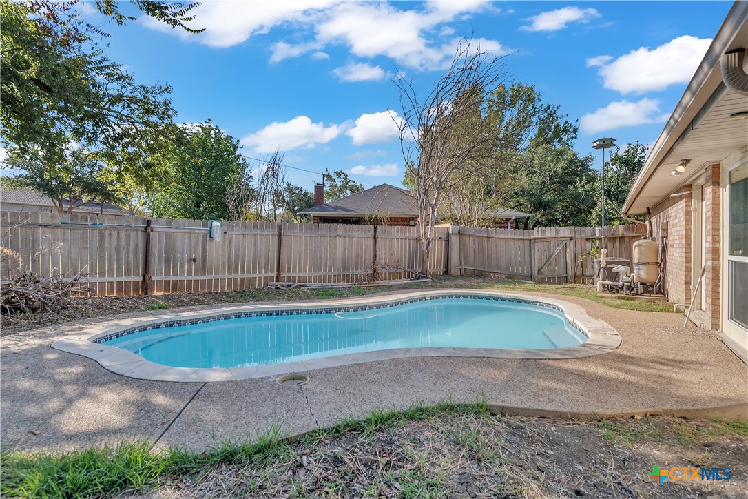 a view of backyard with swimming pool and outdoor seating