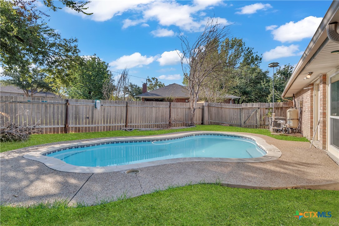 a view of a backyard with swimming pool