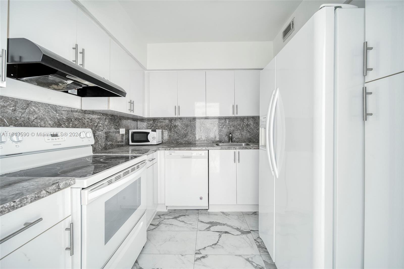 a kitchen with white cabinets and white appliances