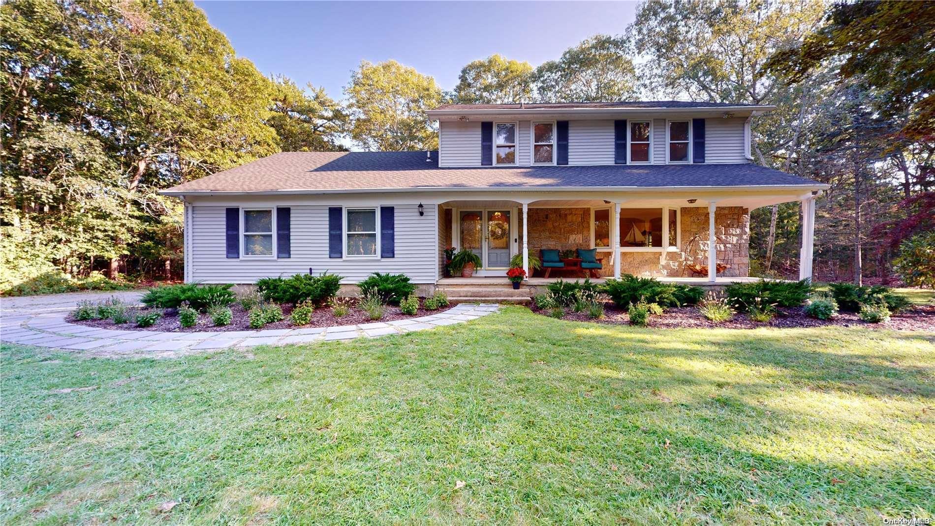 a front view of a house with yard and green space