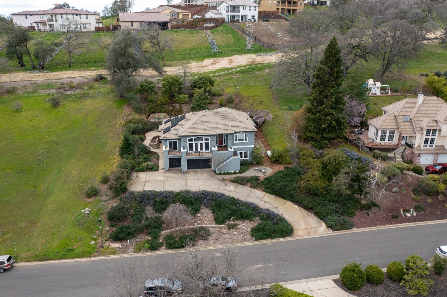 an aerial view of a house with a garden and lake view