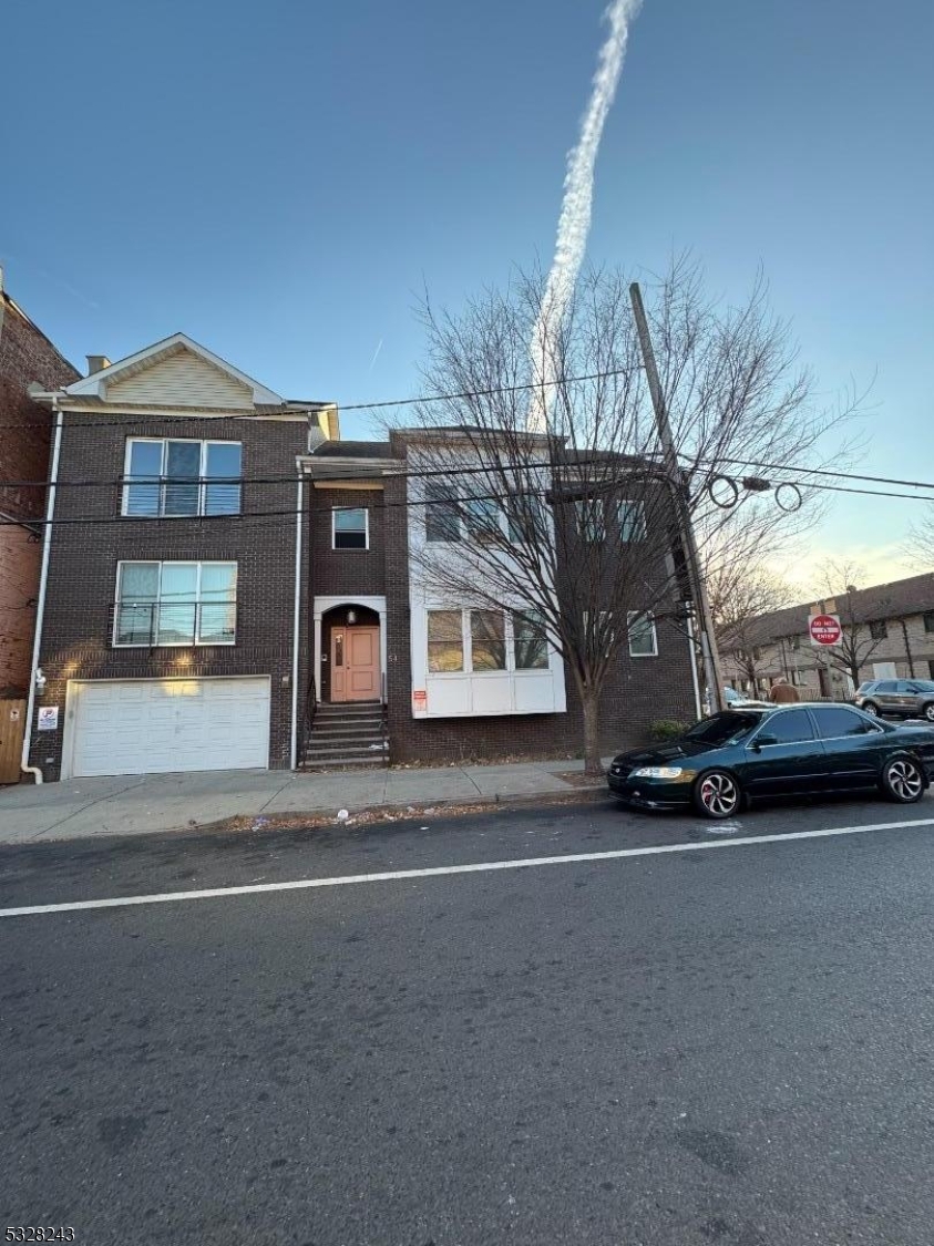 a front view of a house with a road