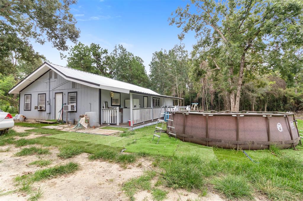 a view of a house with backyard and trees