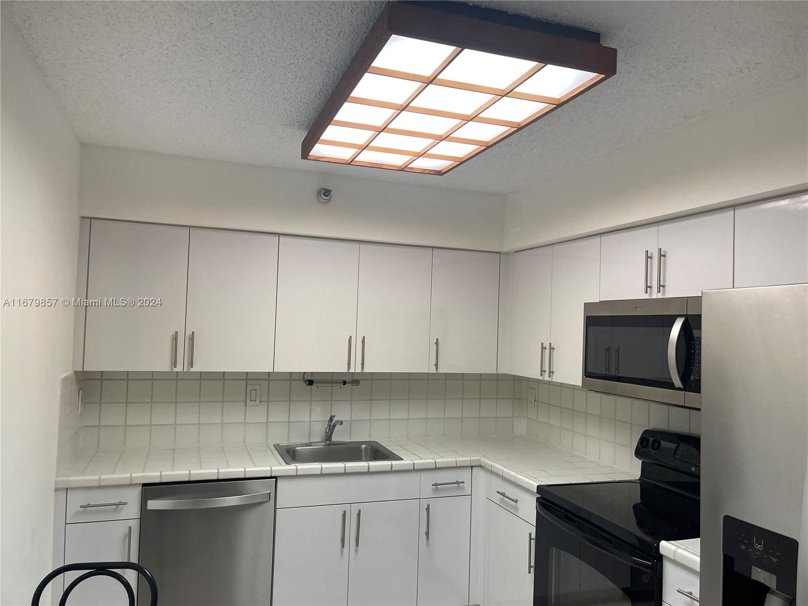 a kitchen with a sink cabinets and window