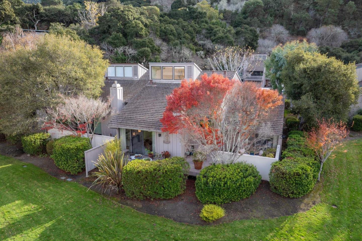 an aerial view of a house with a yard and greenery