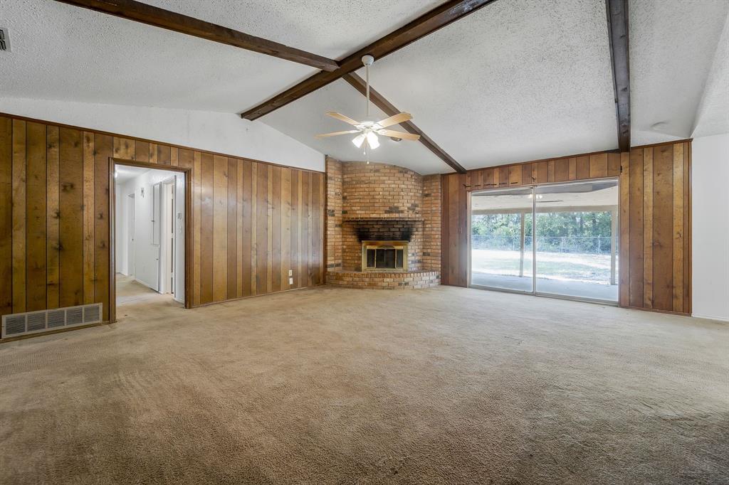 a view of an empty room with a fireplace and a window